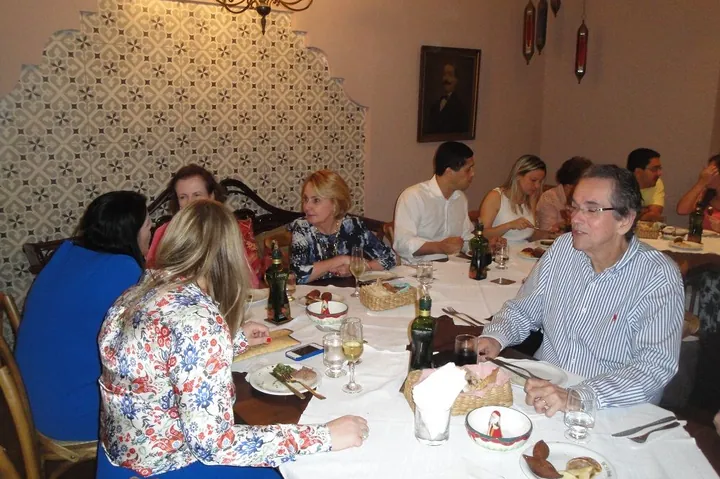 Convidados à mesa em evento no salão do Empório Árabe